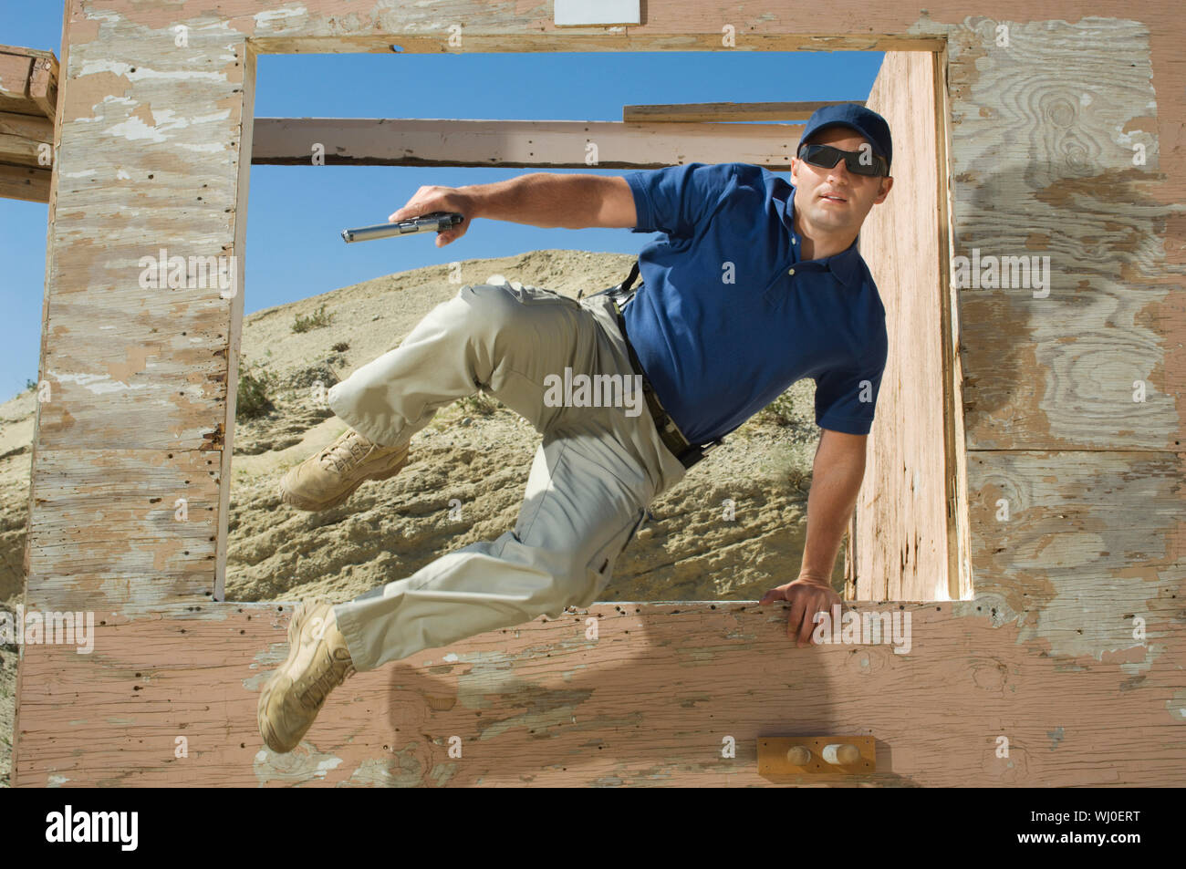 Man with hand gun jumping obstacle at firing range Stock Photo Alamy