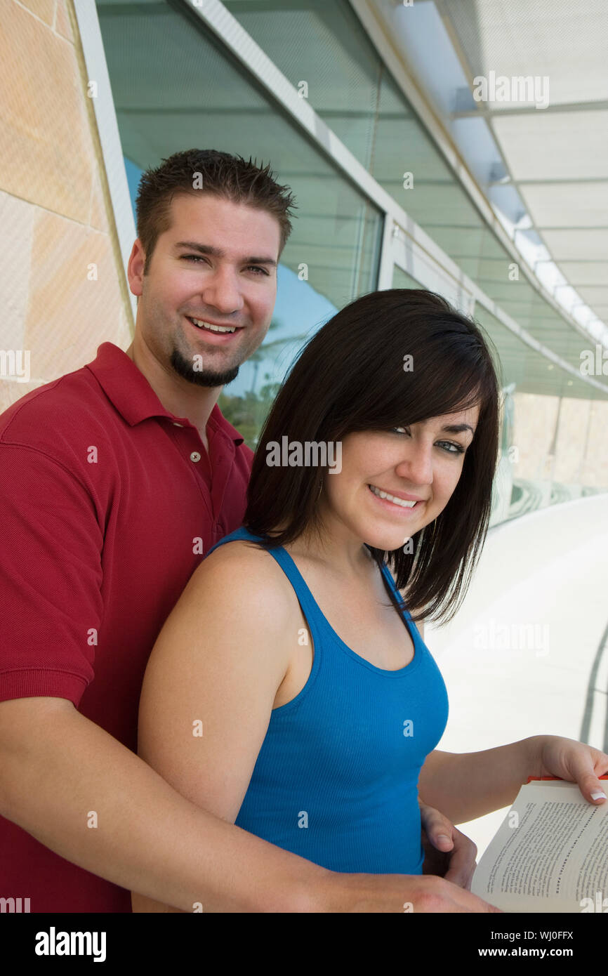 Two students holding books at school, smiling, portrait Stock Photo - Alamy