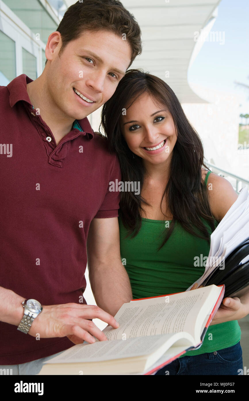 Two students holding books at school, smiling, portrait Stock Photo - Alamy