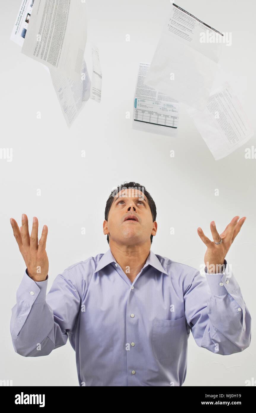 Mature businessman throwing bills isolated over white background Stock