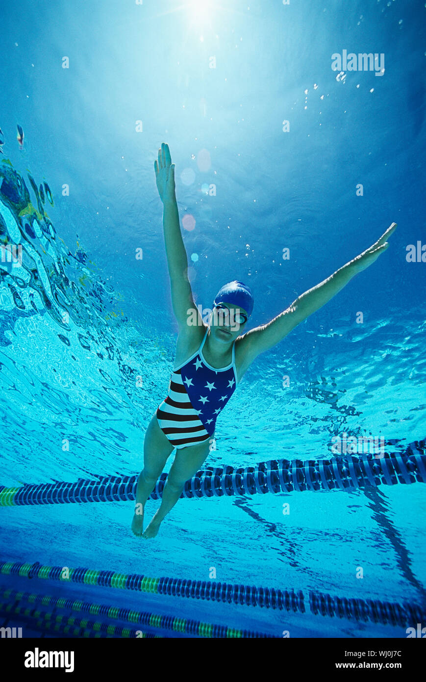 Female swimmer wearing United States swimsuit, swimming in pool Stock Photo