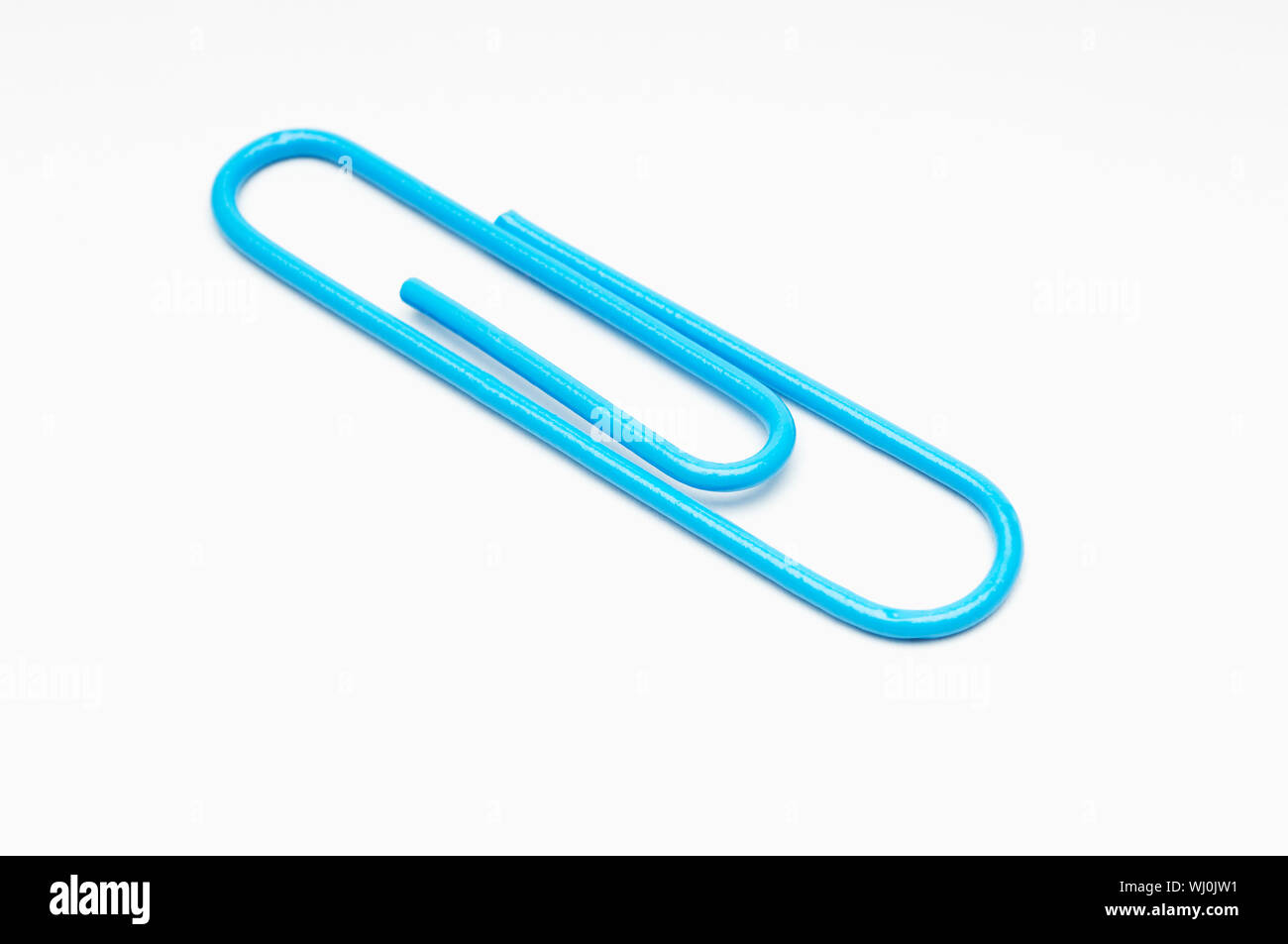 Blue paper clip on white background Stock Photo - Alamy