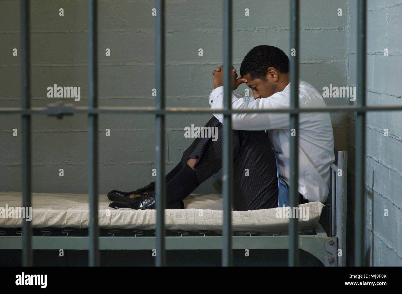 Mature man sitting on bed in prison cell Stock Photo Alamy