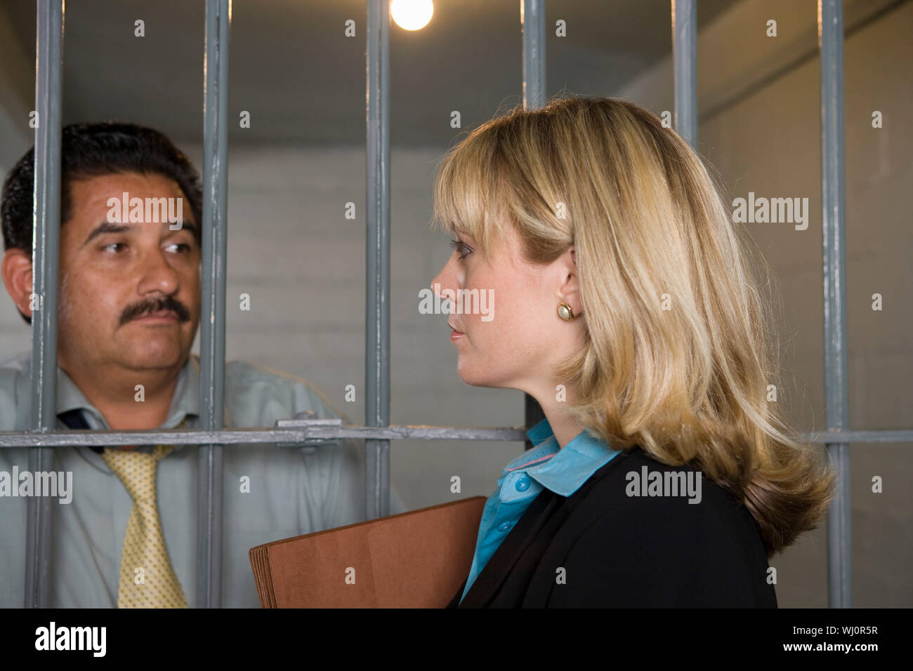 Lawyer with criminal behind bars in jail Stock Photo Alamy