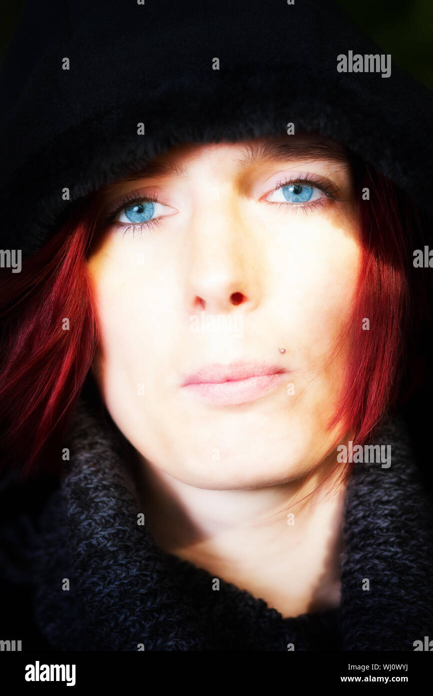 Close up head portrait of a beautiful redhead woman with startling blue eyes and a serene expression Stock Photo