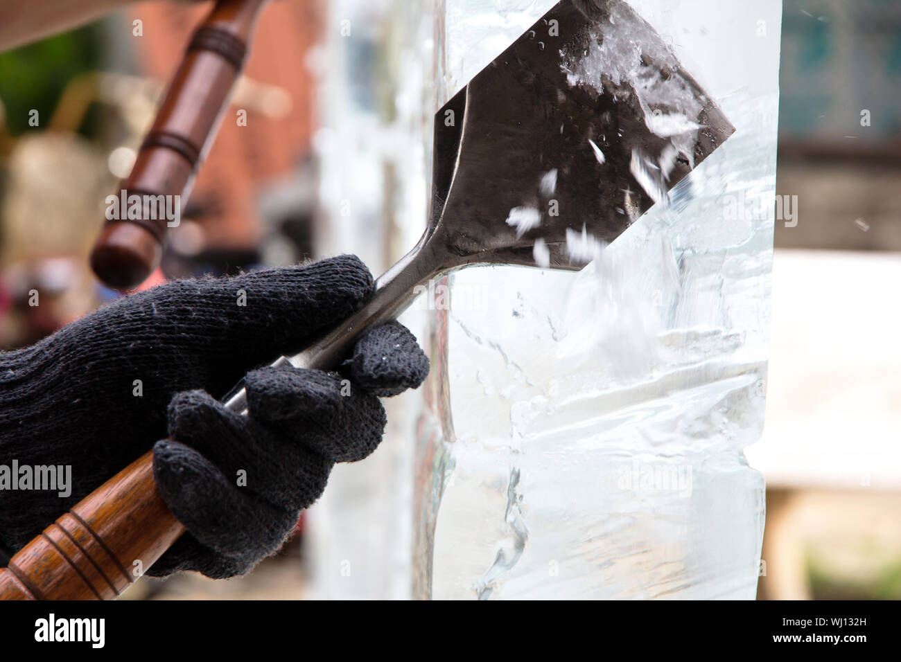 Ice Carver Using Chisel to Carve Stock Photo
