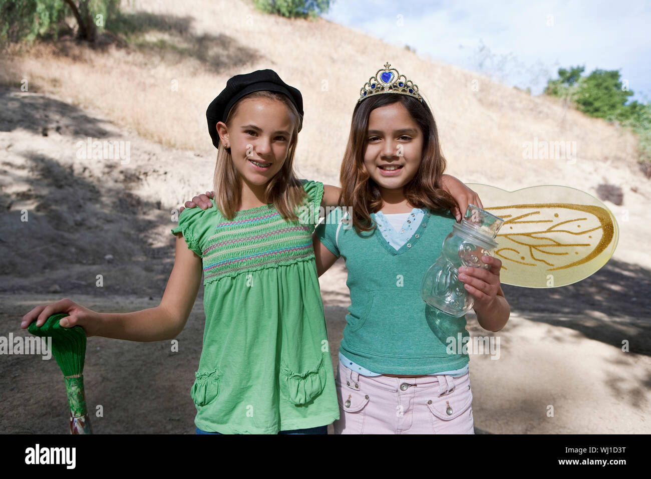 Portrait of two smiling girls in costumes standing outdoors Stock Photo ...