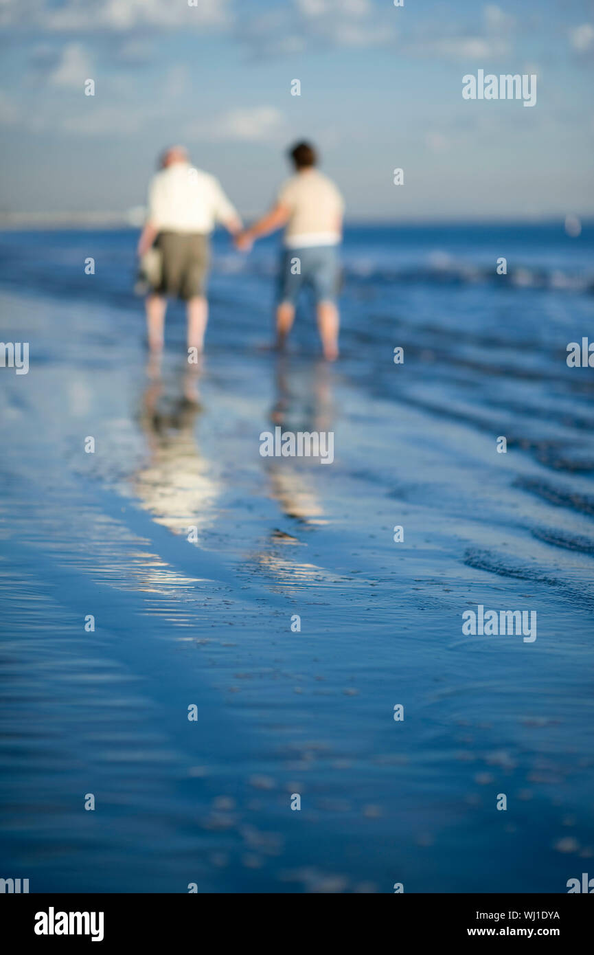 Senior couple walking on beach Stock Photo - Alamy