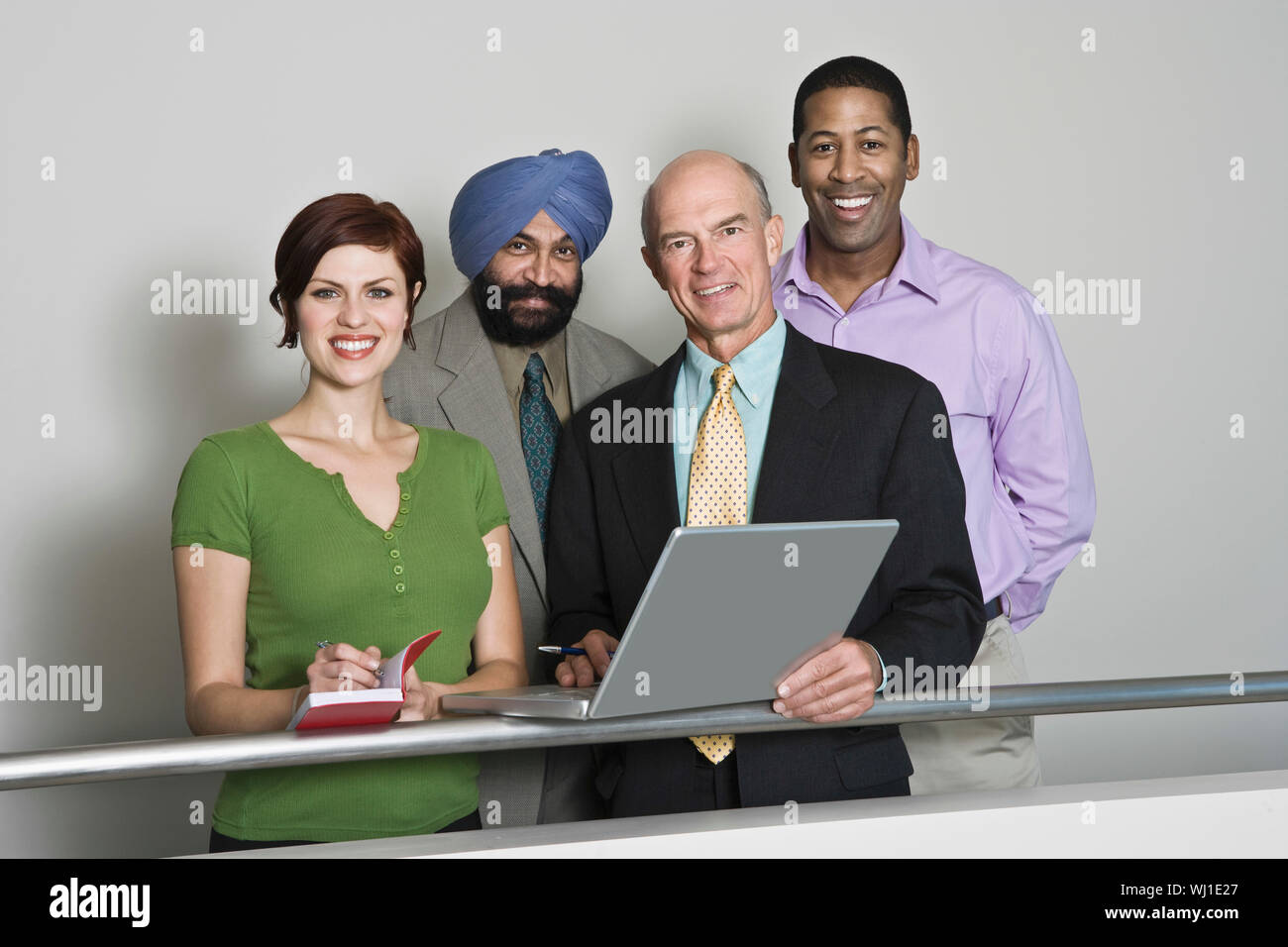 Group portrait of smiling multiethnic businesspeople with laptop Stock Photo