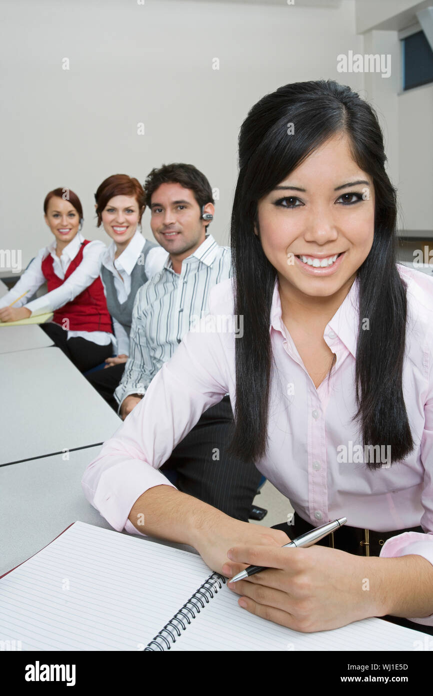 Portrait of smiling multiethnic businesspeople sitting at office desk Stock Photo