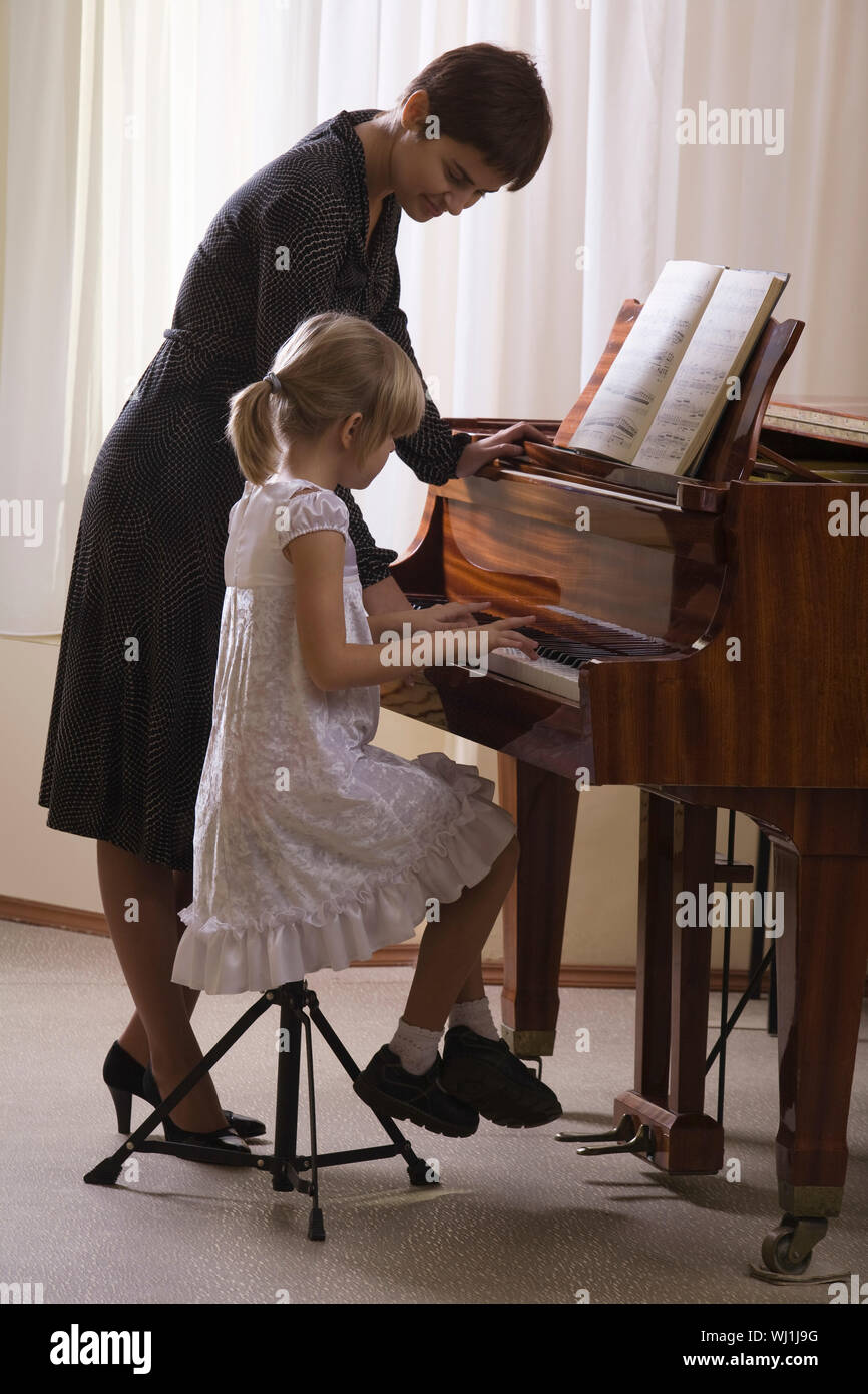 Sister play piano. Учитель фортепиано. Педагог фортепиано. Учитель пианино. Ребенок и учитель за фортепиано.