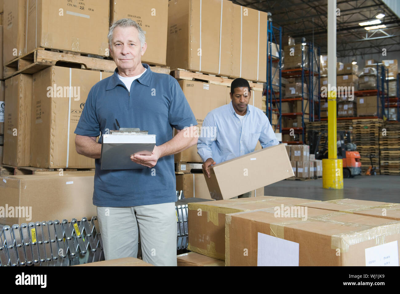 Worker Distribution Portrait of a middle aged man with worker in background at distribution ...