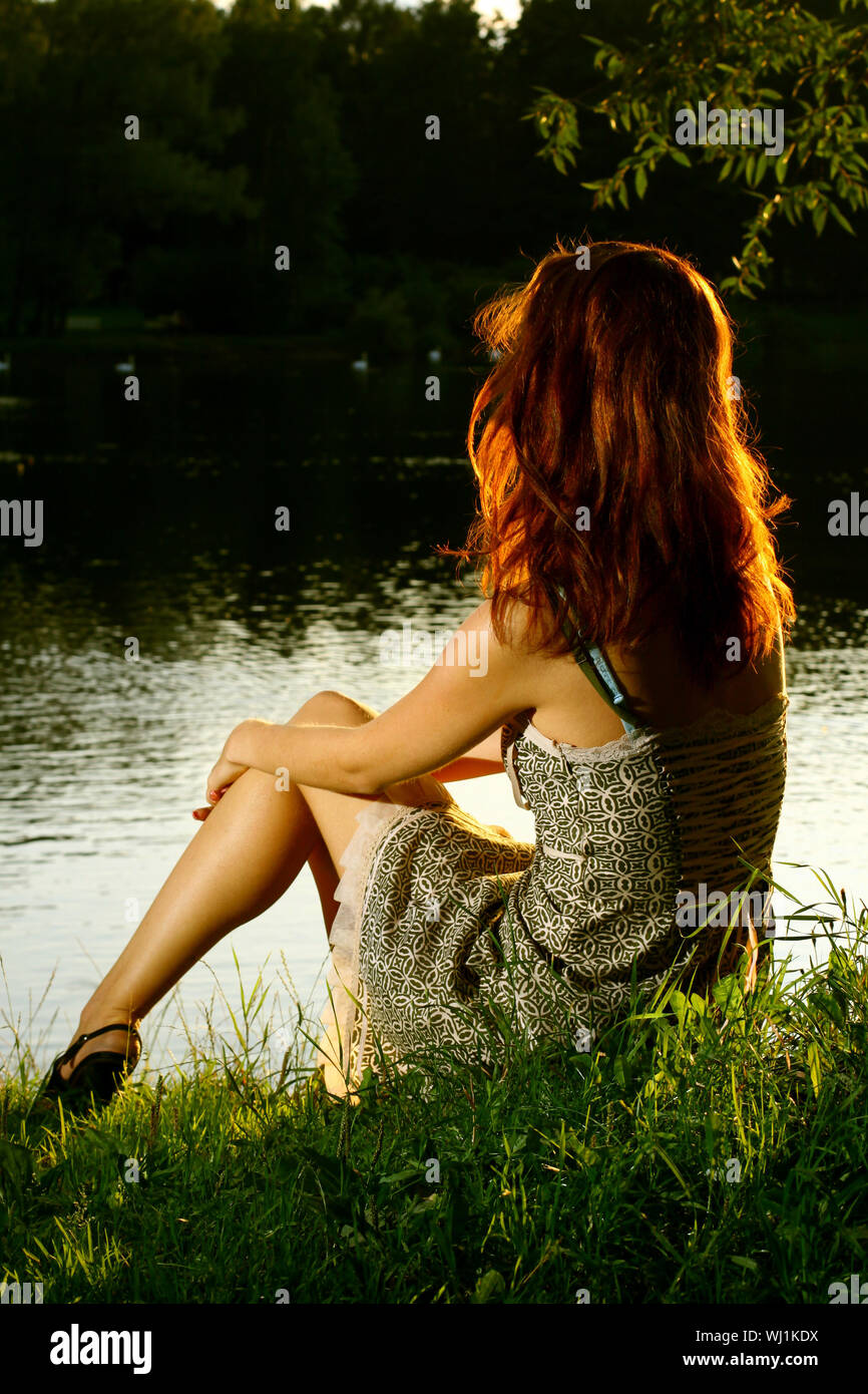 Girl sitting on tha bank of forest river Stock Photo - Alamy