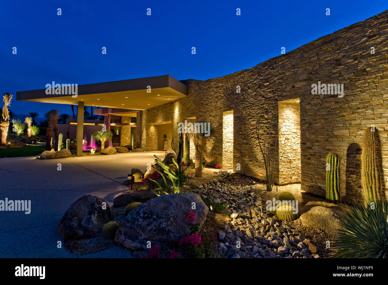 View of an illuminated modern house exterior against the sky at dusk ...