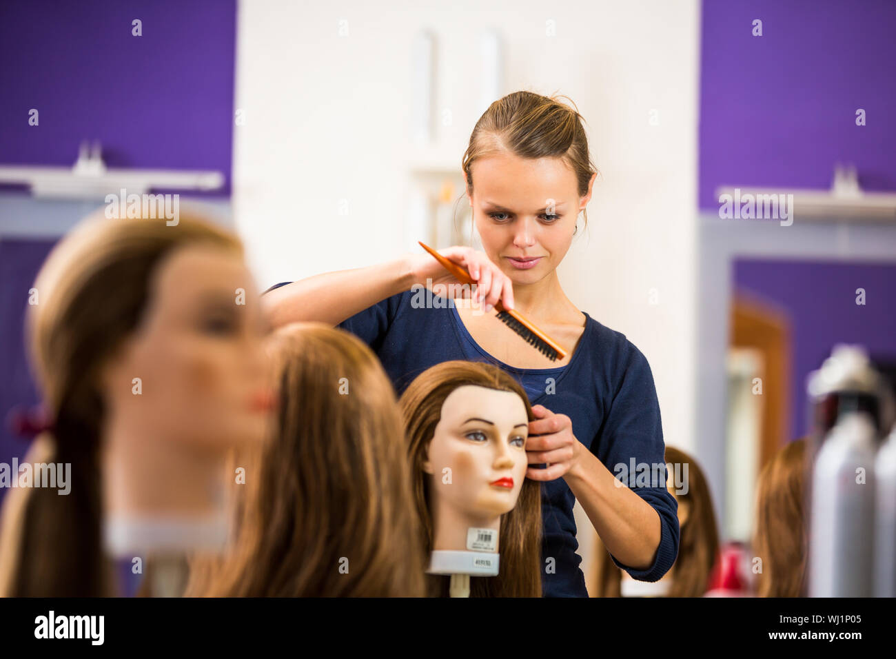 Pretty female hairdresser/haidressing apprentice/student training on an ...