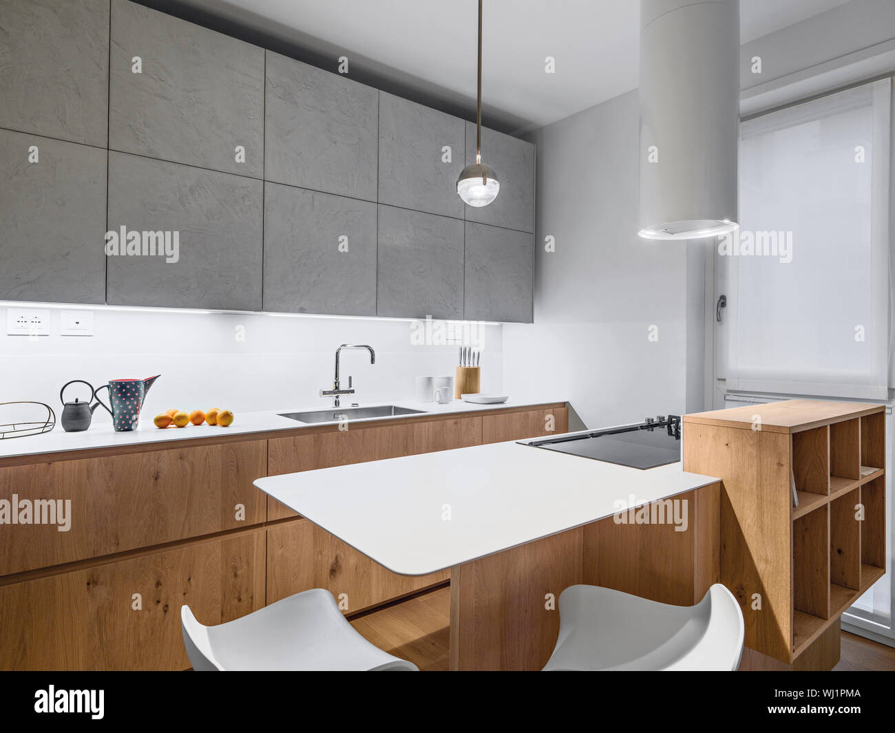 interiors shots of a modern wooden kitchen in foreground the kitcehn island Stock Photo