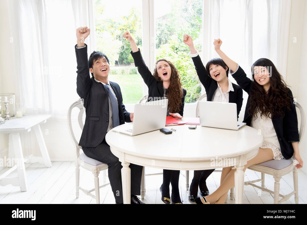 Successful businesspeople with hand raised Stock Photo