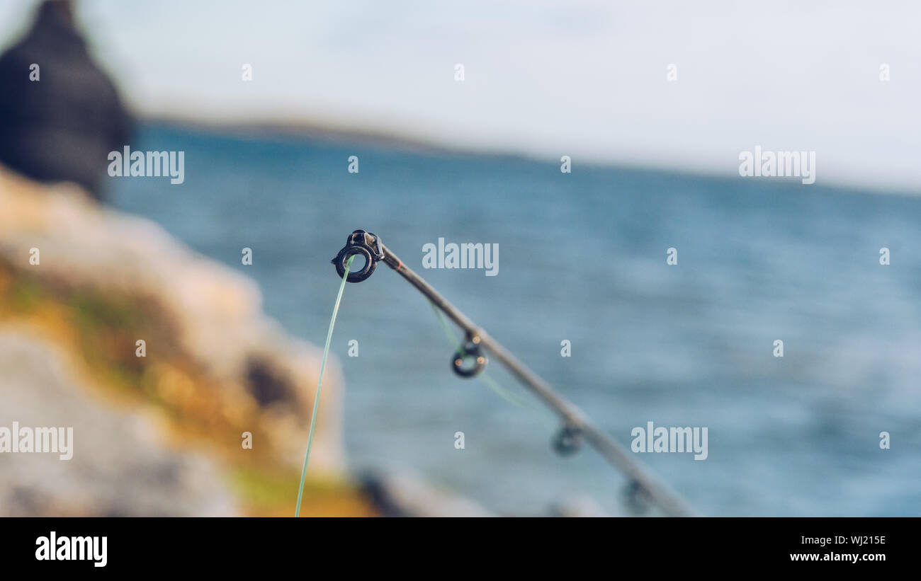 Close-up Of Fishing Rod Against Lake Stock Photo