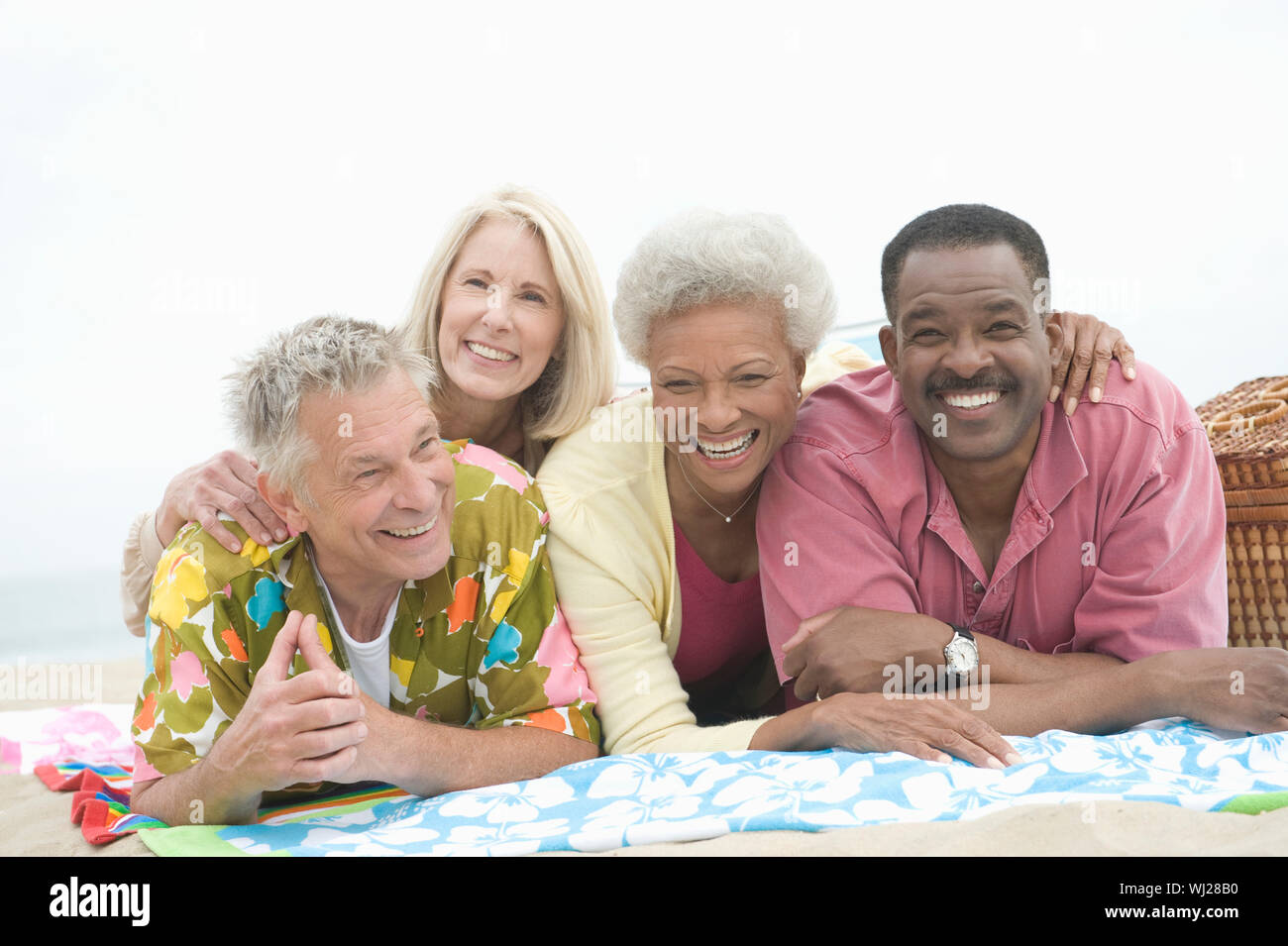 Happy multi ethnic friends lying on blanket at beach Stock Photo - Alamy