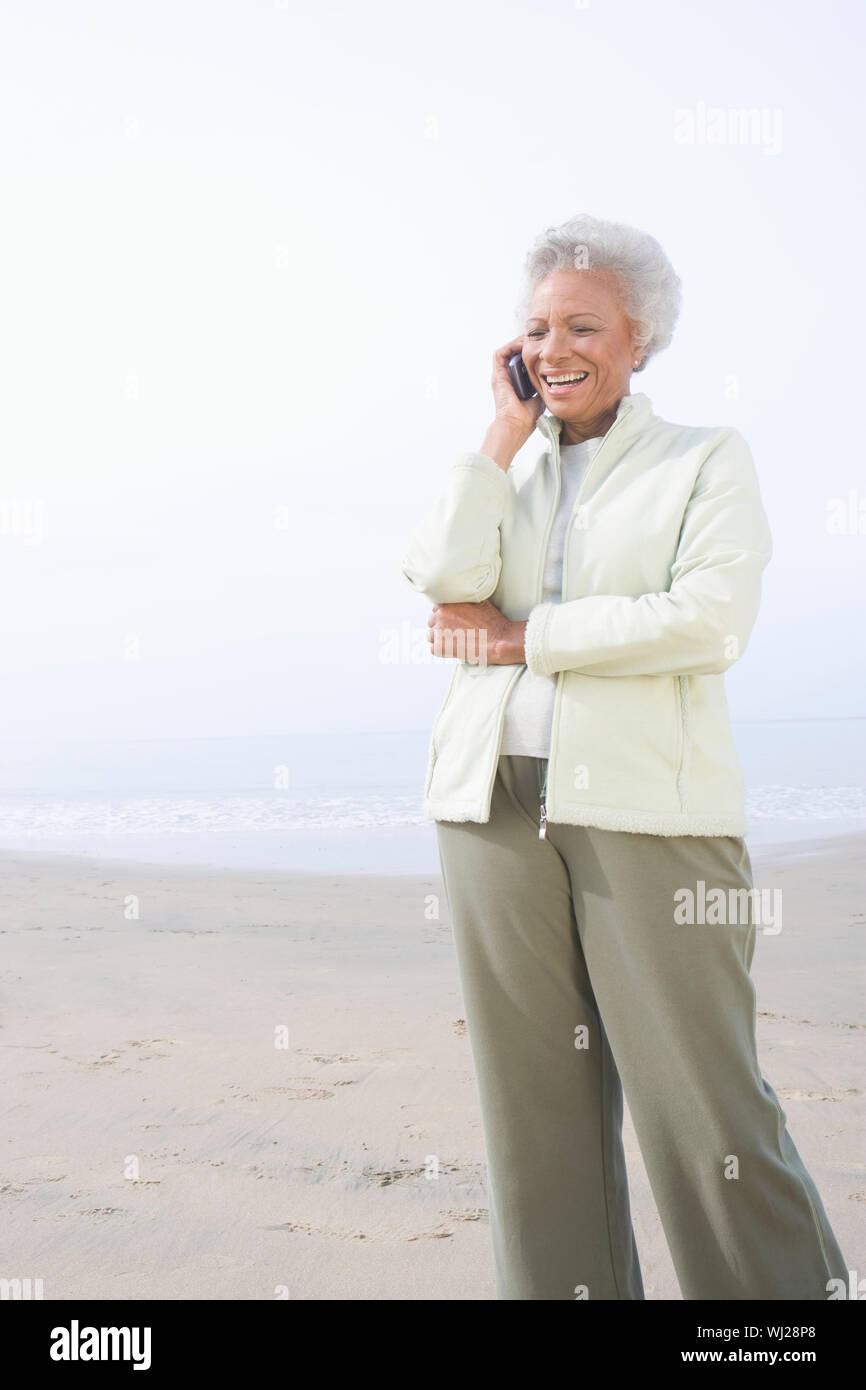 An African American happy senior woman on call at beach Stock Photo - Alamy