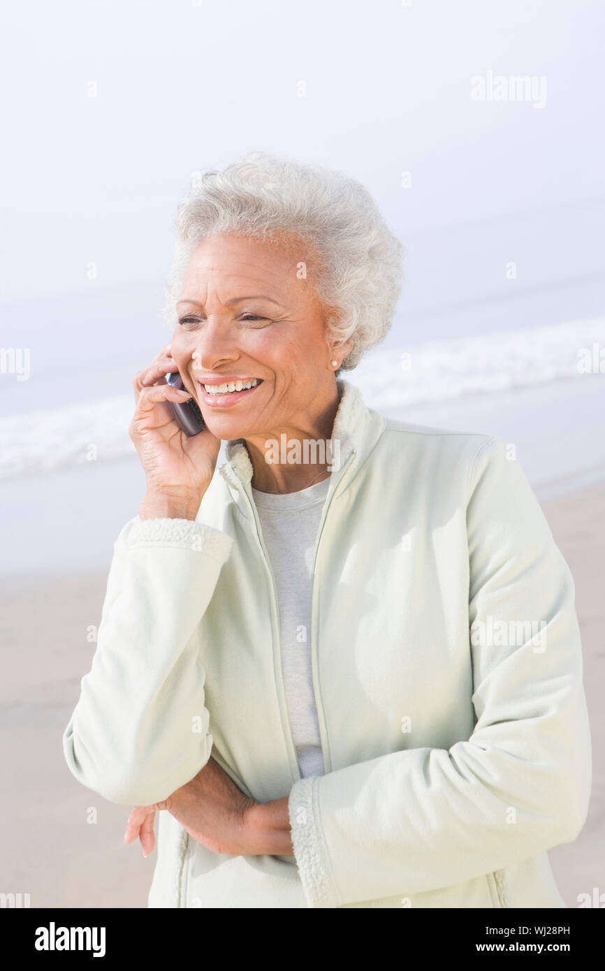 An African American happy senior woman on call at beach Stock Photo - Alamy