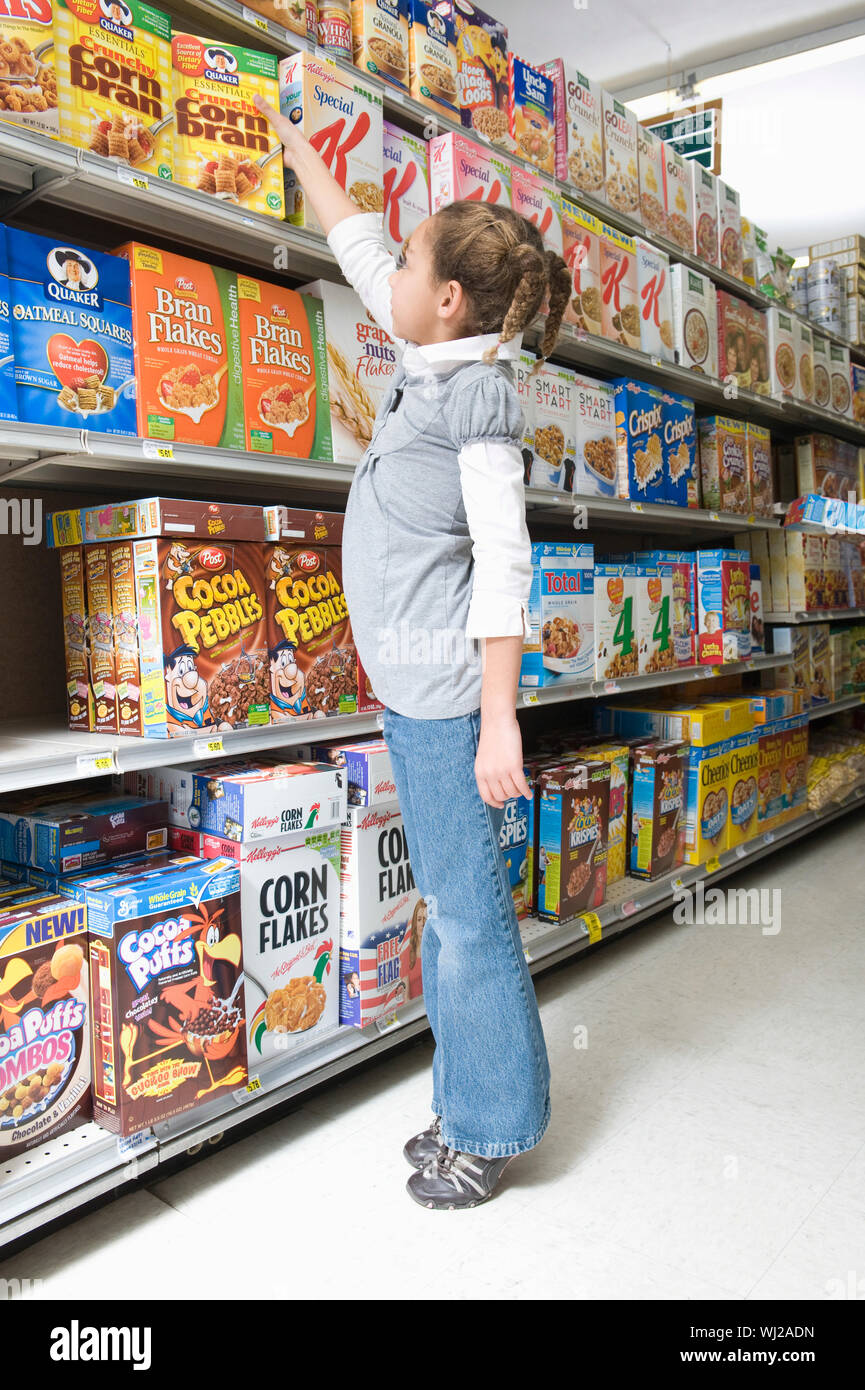 Full Length Side View Of A Young Girl Reaching For Cereal Product In Supermarket Aisle Stock Photo Alamy