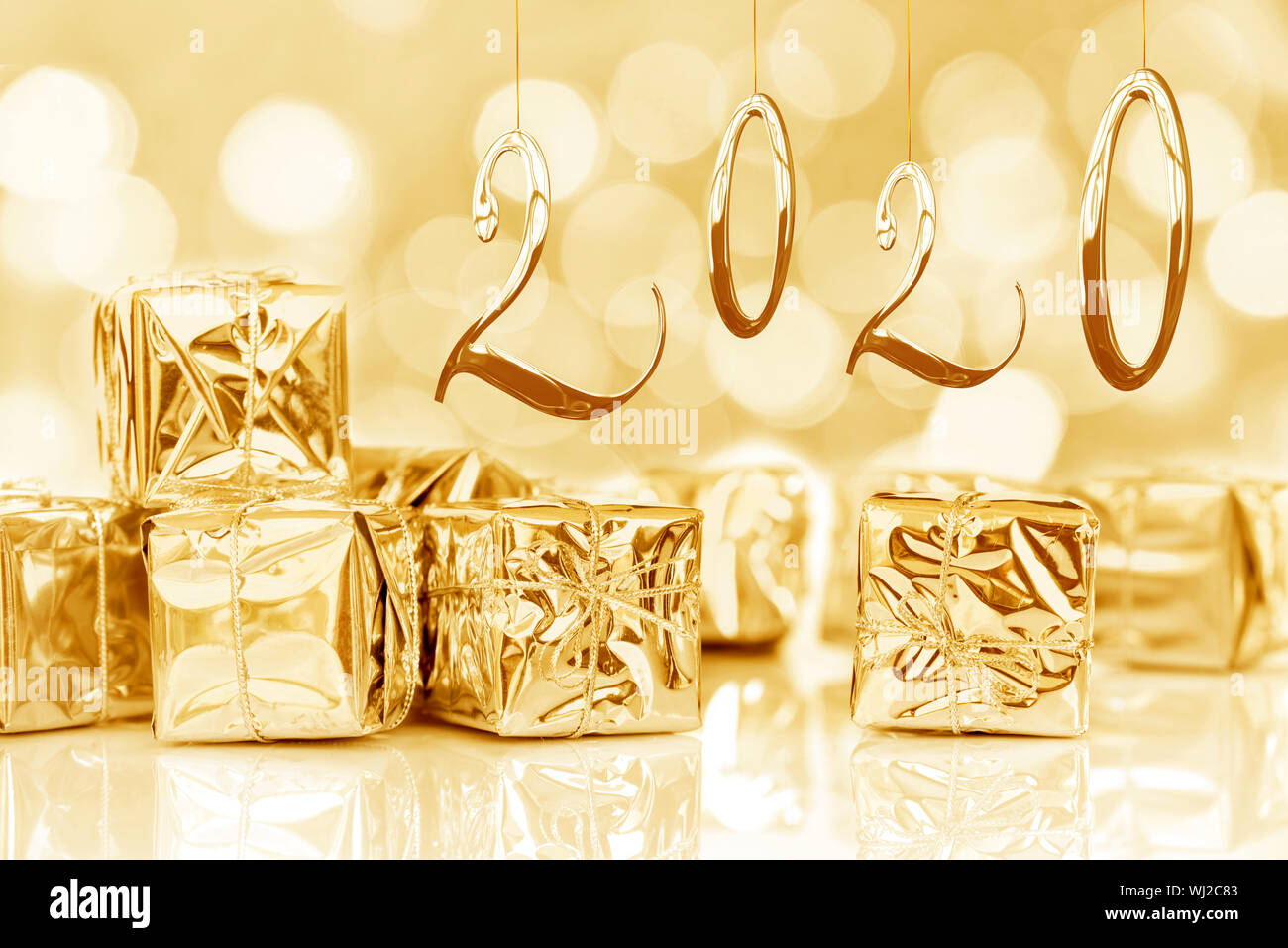 2020, new year card, small Christmas gifts in shiny golden paper, bokeh lights background Stock Photo