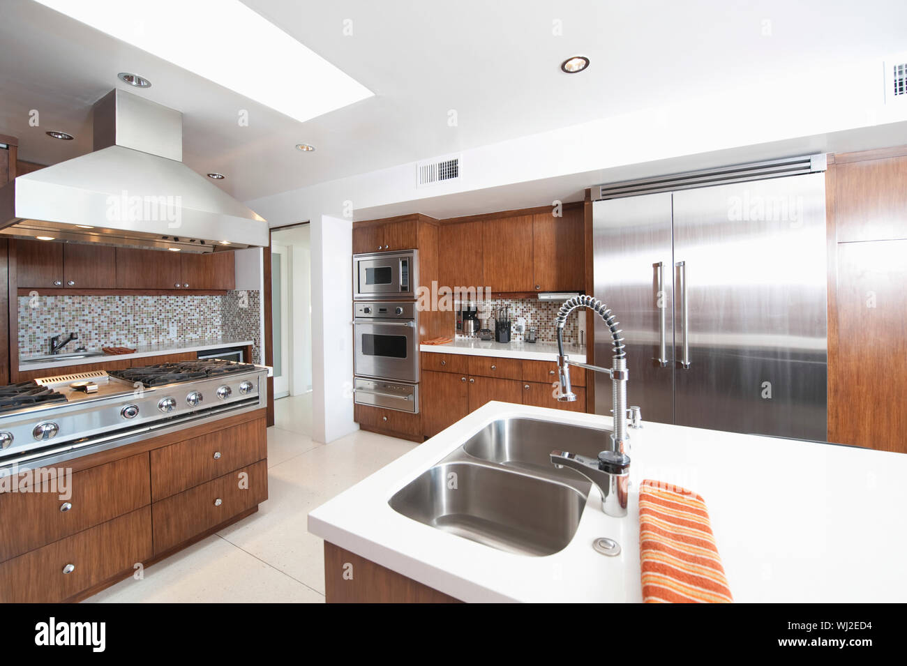 Wood and stainless steel kitchen in modern house Stock Photo - Alamy