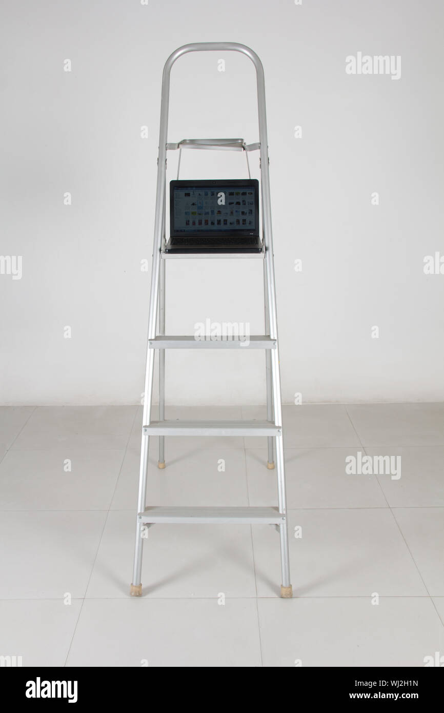 Open Laptop on step ladder Stock Photo