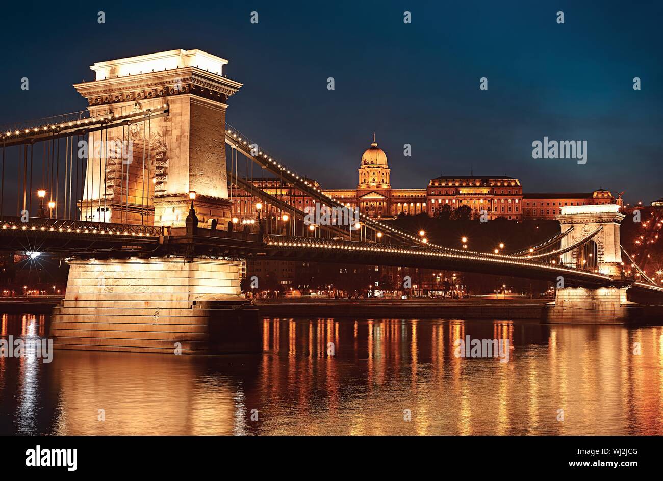 Dusk cityscape of the Chain bridge across the river Danube with the Buda castle in the background in the Hungarian capital  Budapest Stock Photo