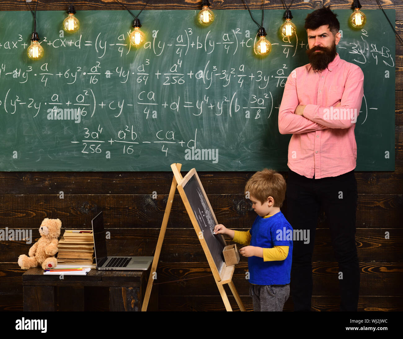 Strict math teacher checking pupil s work. Blond schoolboy solving ...