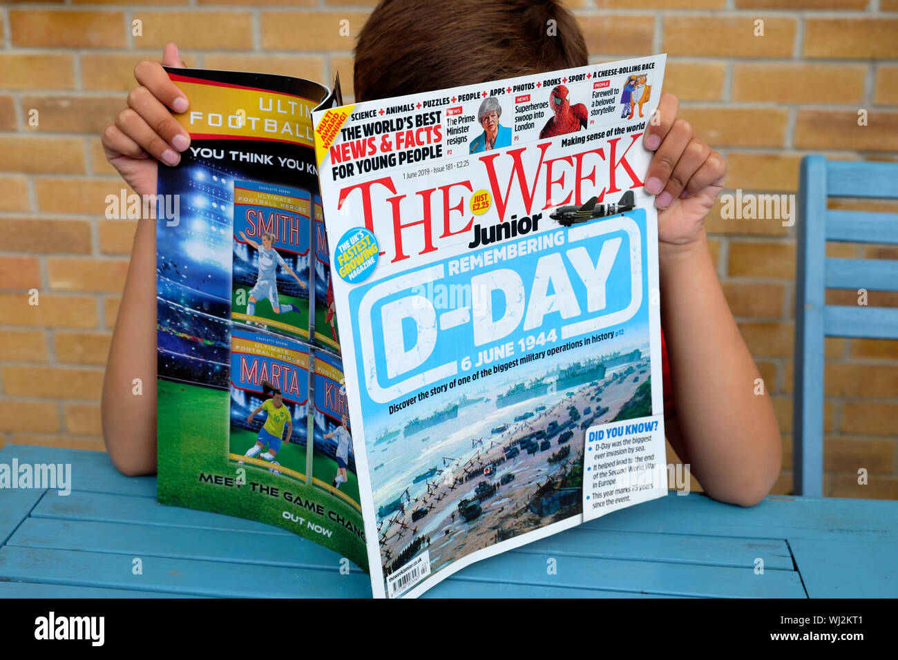 A child reading The Week Junior magazine British weekly publication for young people with D-Day memorial front cover in Great Britain UK  KATHY DEWITT Stock Photo