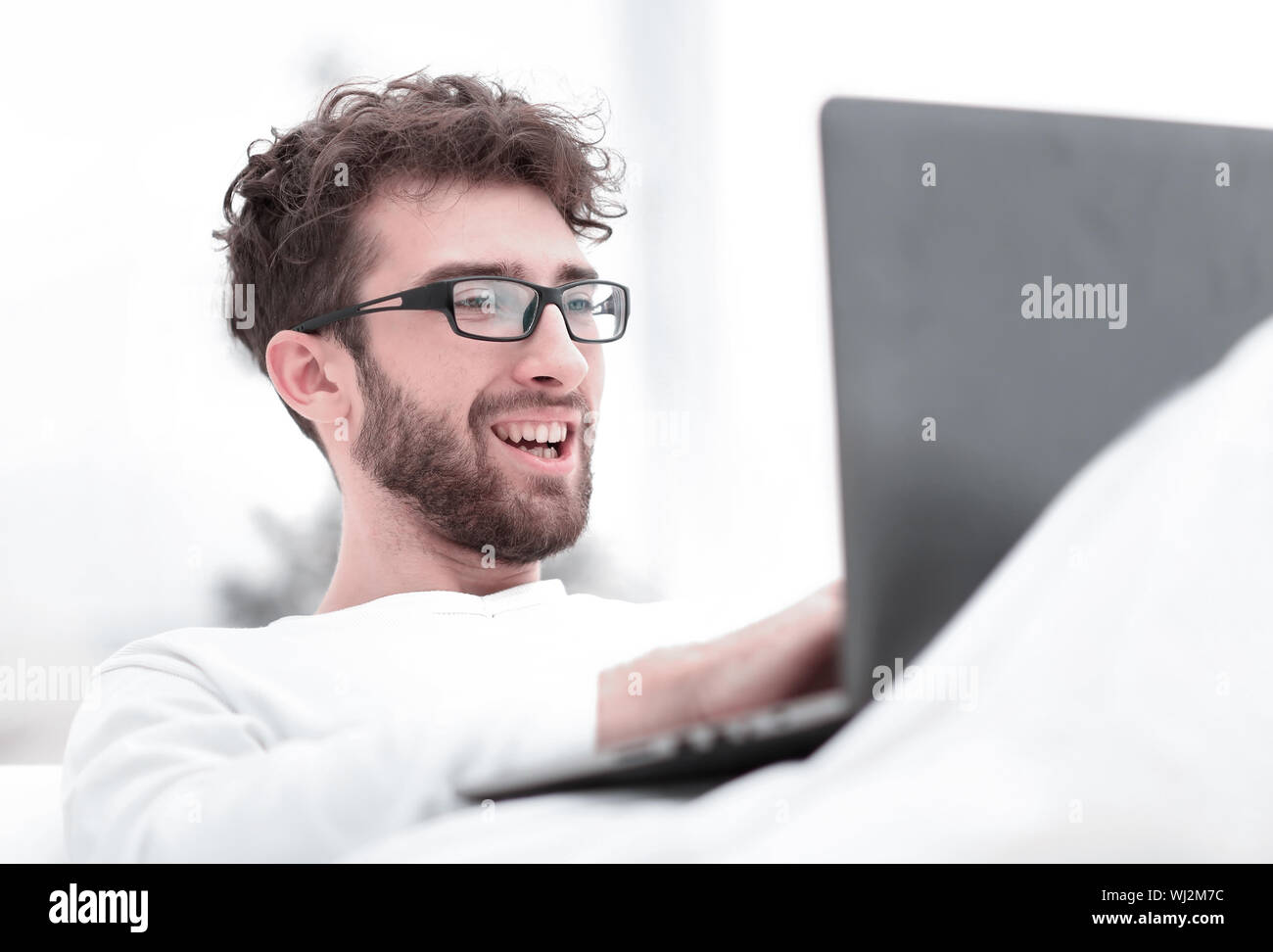 handsome man working on laptop lying on bed Stock Photo - Alamy