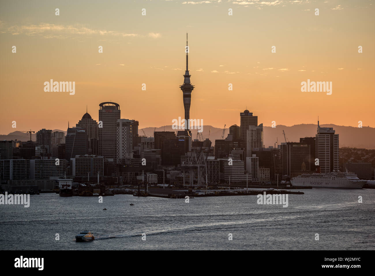 Auckland skyline and city tower, view from Devonport, at sunset Stock Photo