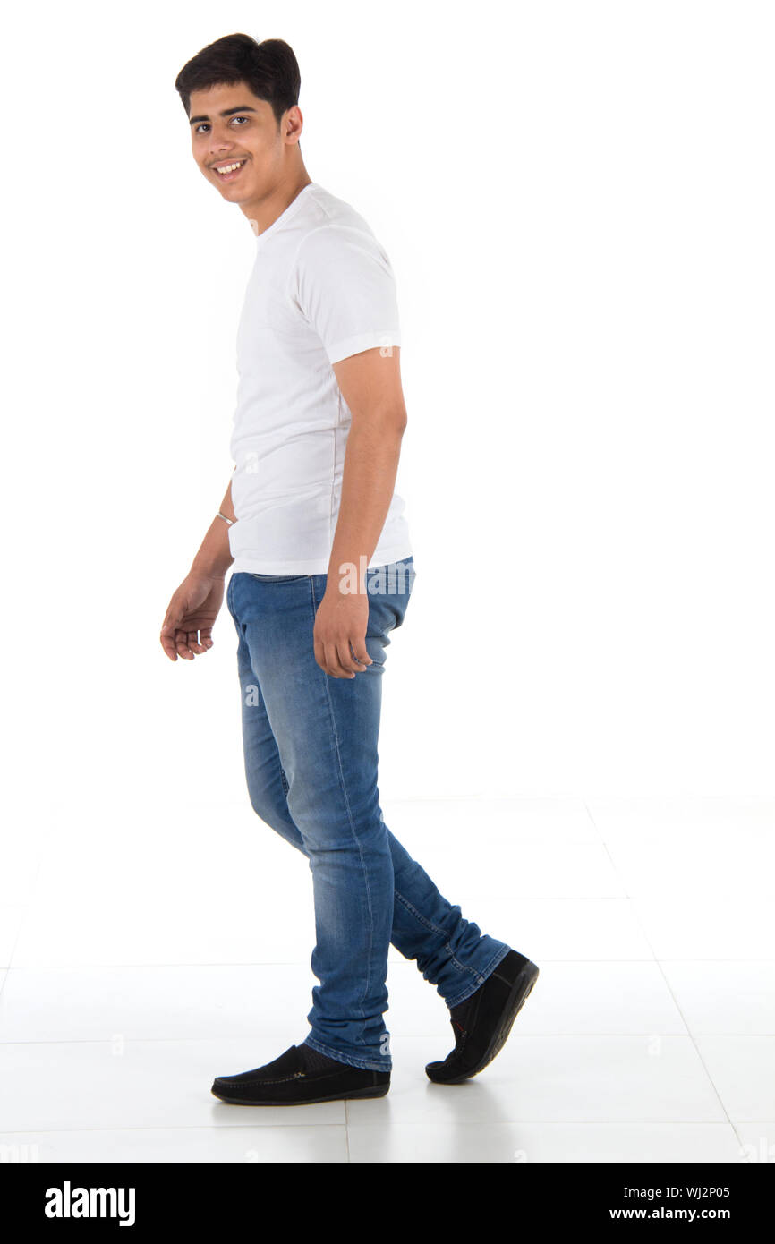 Side profile of an Indian young man walking and smiling Stock Photo