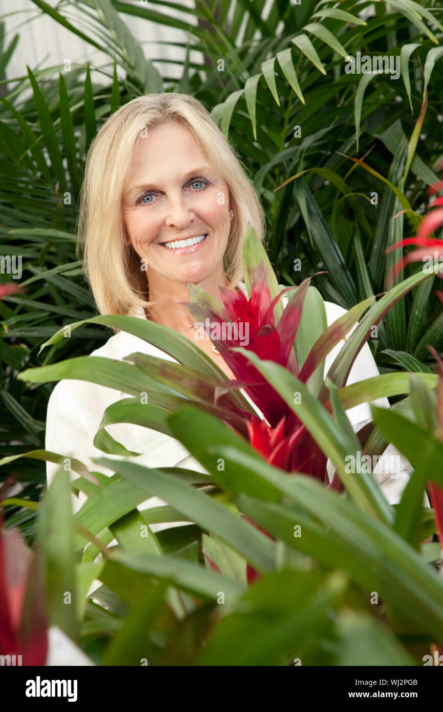Portrait of a cheerful senior woman in garden center Stock Photo - Alamy