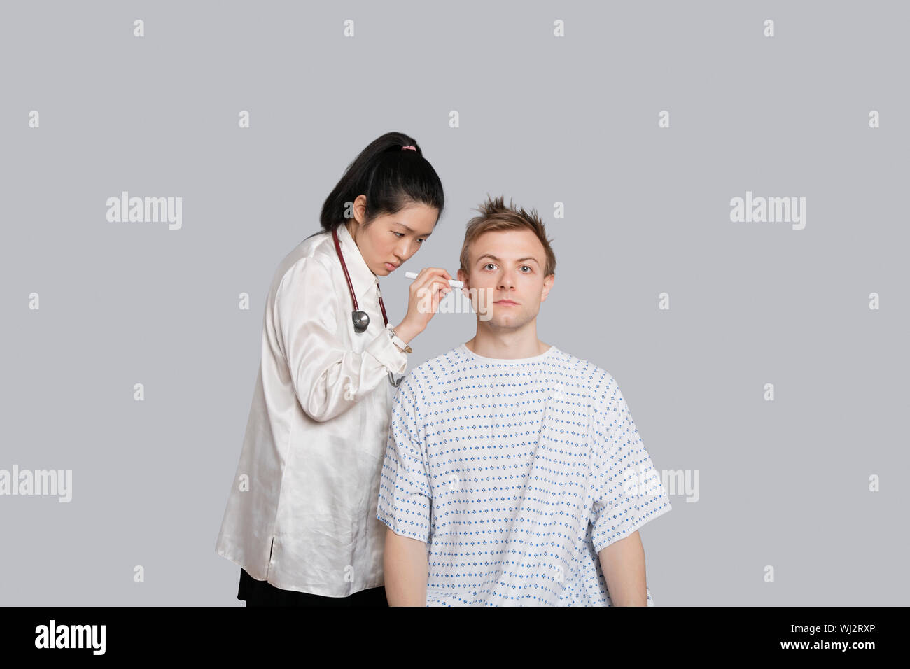 Doctor examining patient's ear with flashlight Stock Photo Alamy