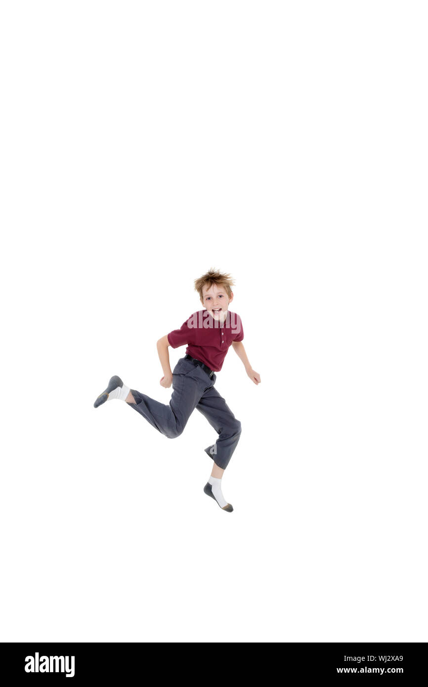 Portrait of cheerful pre-teen boy jumping over white background Stock Photo