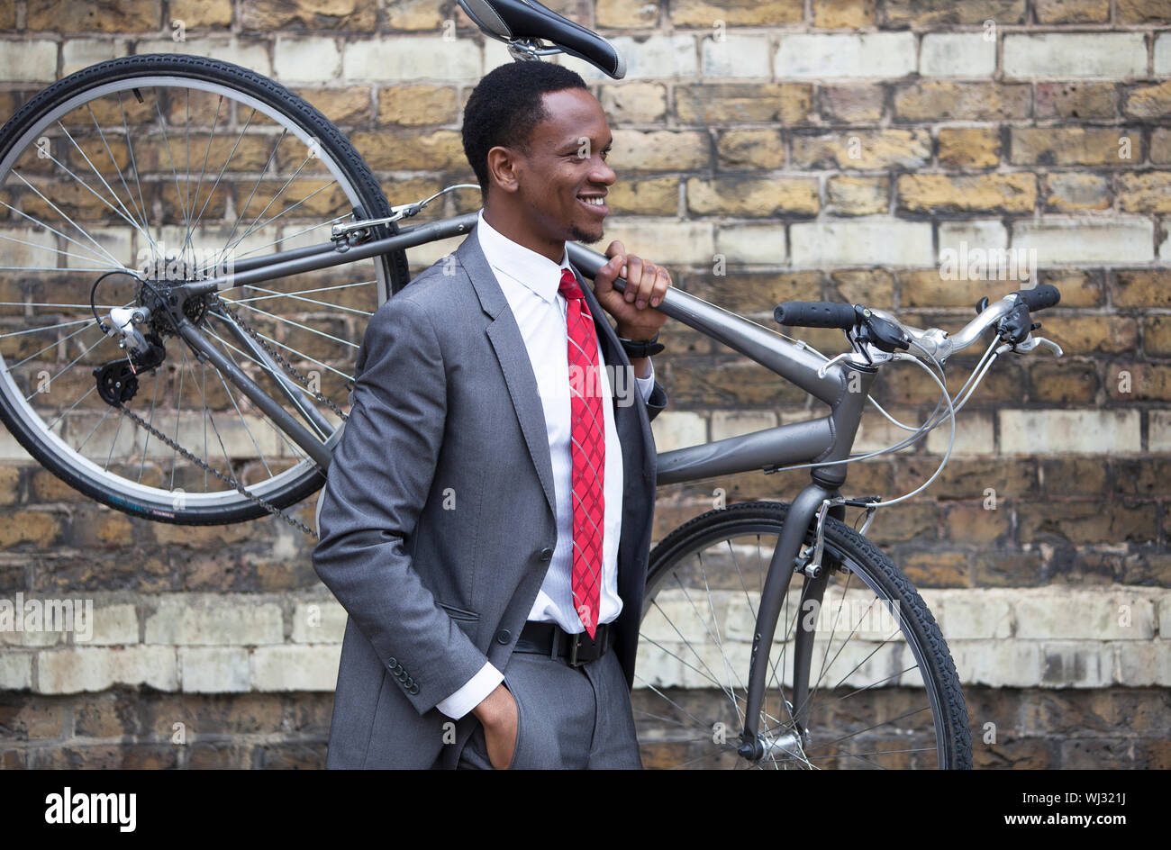 Portrait of African American businessman carrying Bicycle Stock Photo