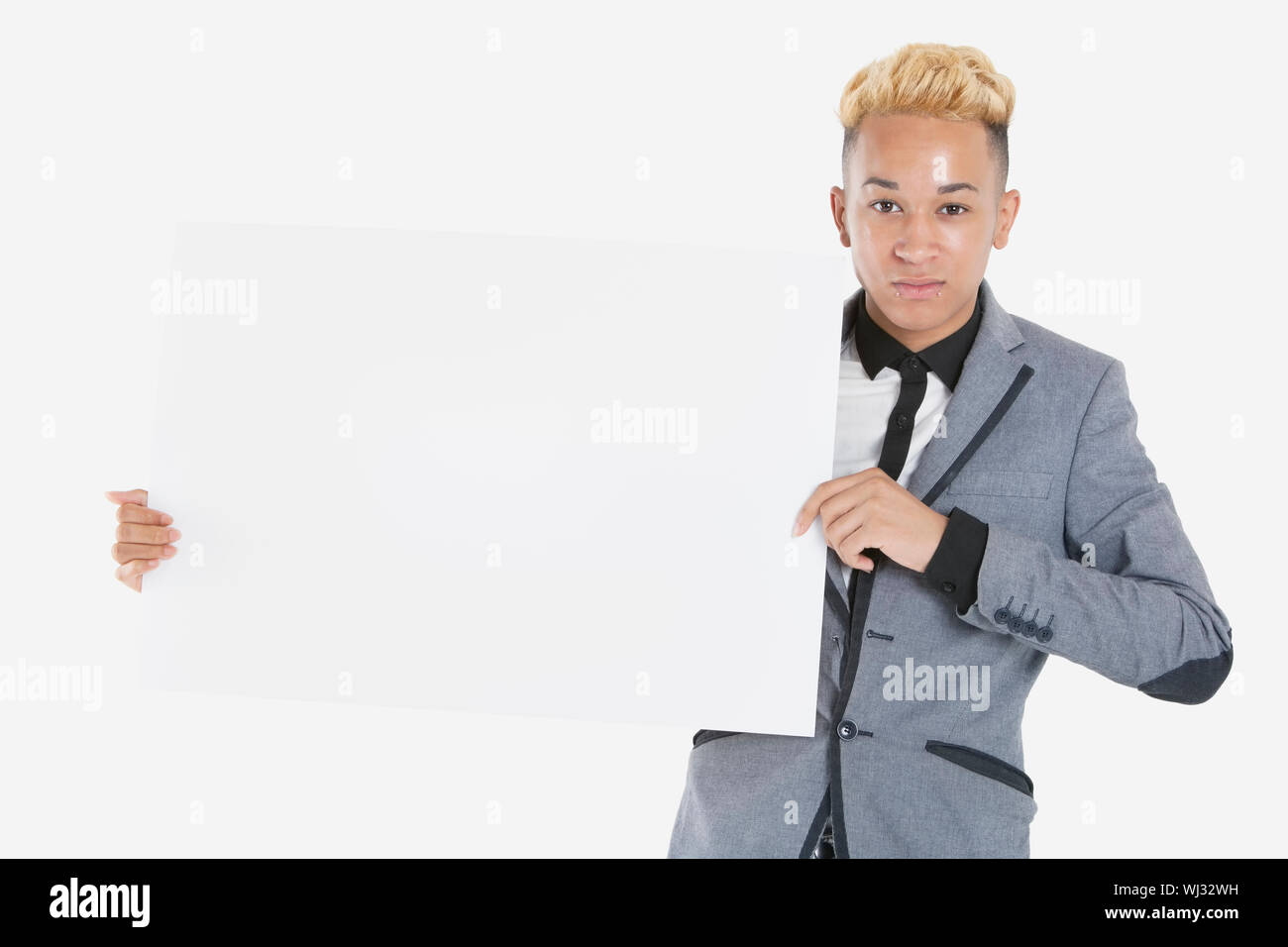 Portrait of a teenage boy holding blank cardboard over gray background ...