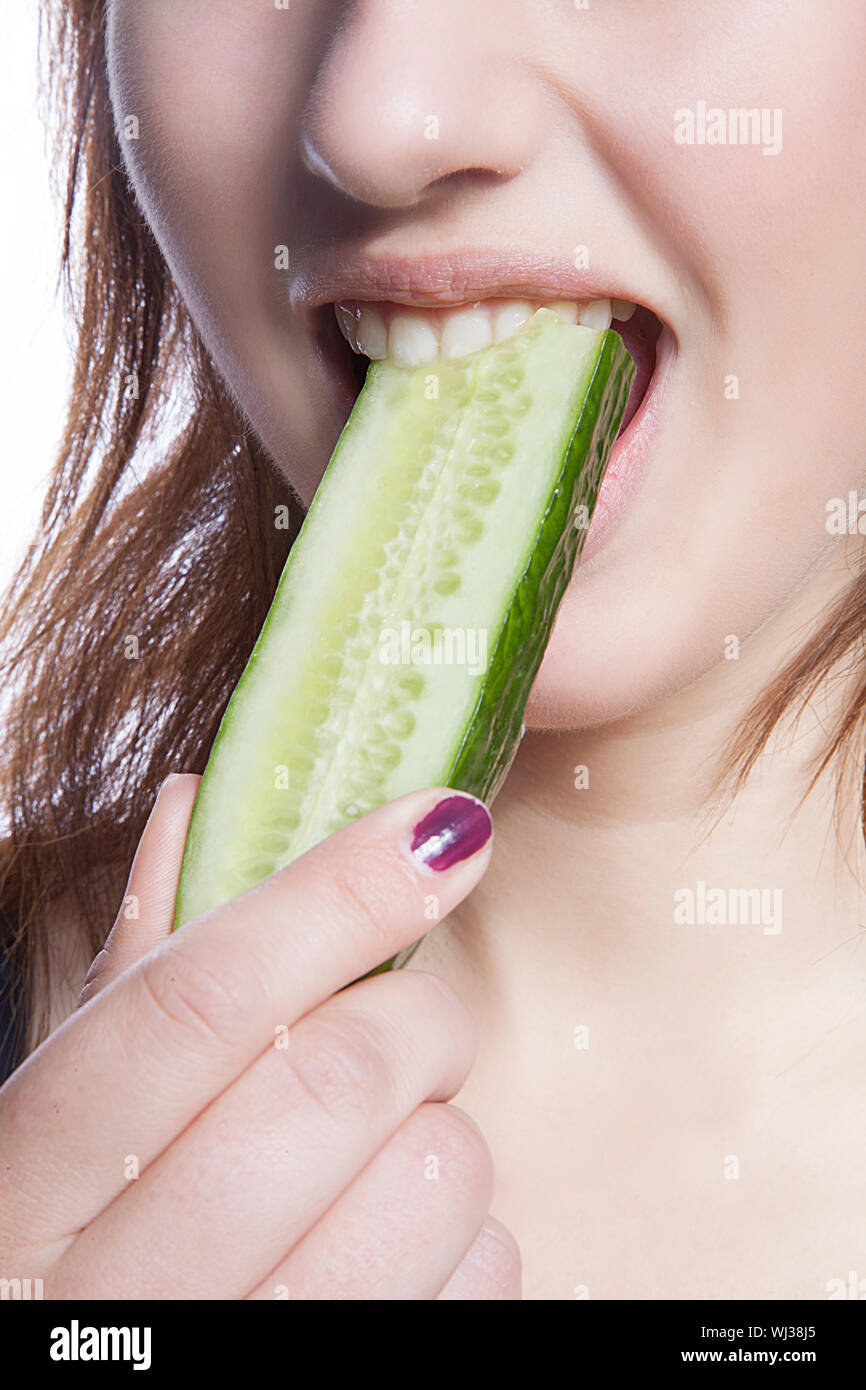 detail-shot-of-woman-eating-cucumber-over-white-background-WJ38J5.jpg