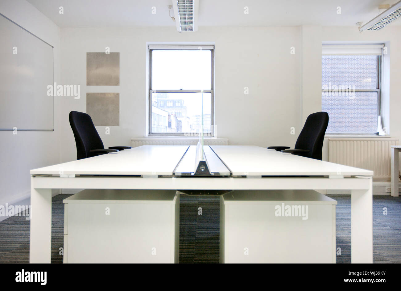Empty office desks back to back Stock Photo Alamy