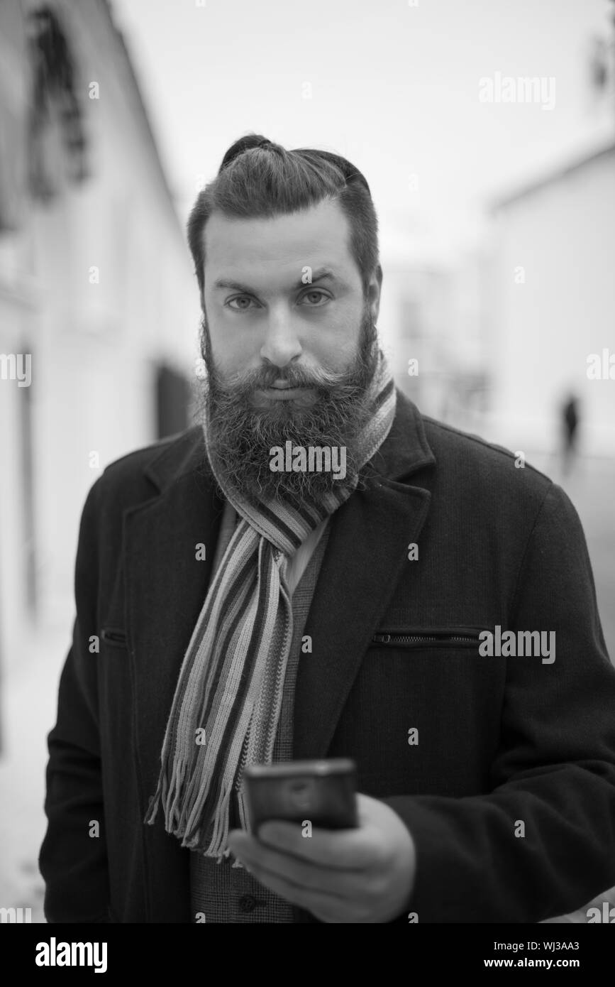 A man with a beard with a phone. black and white photo. Stock Photo