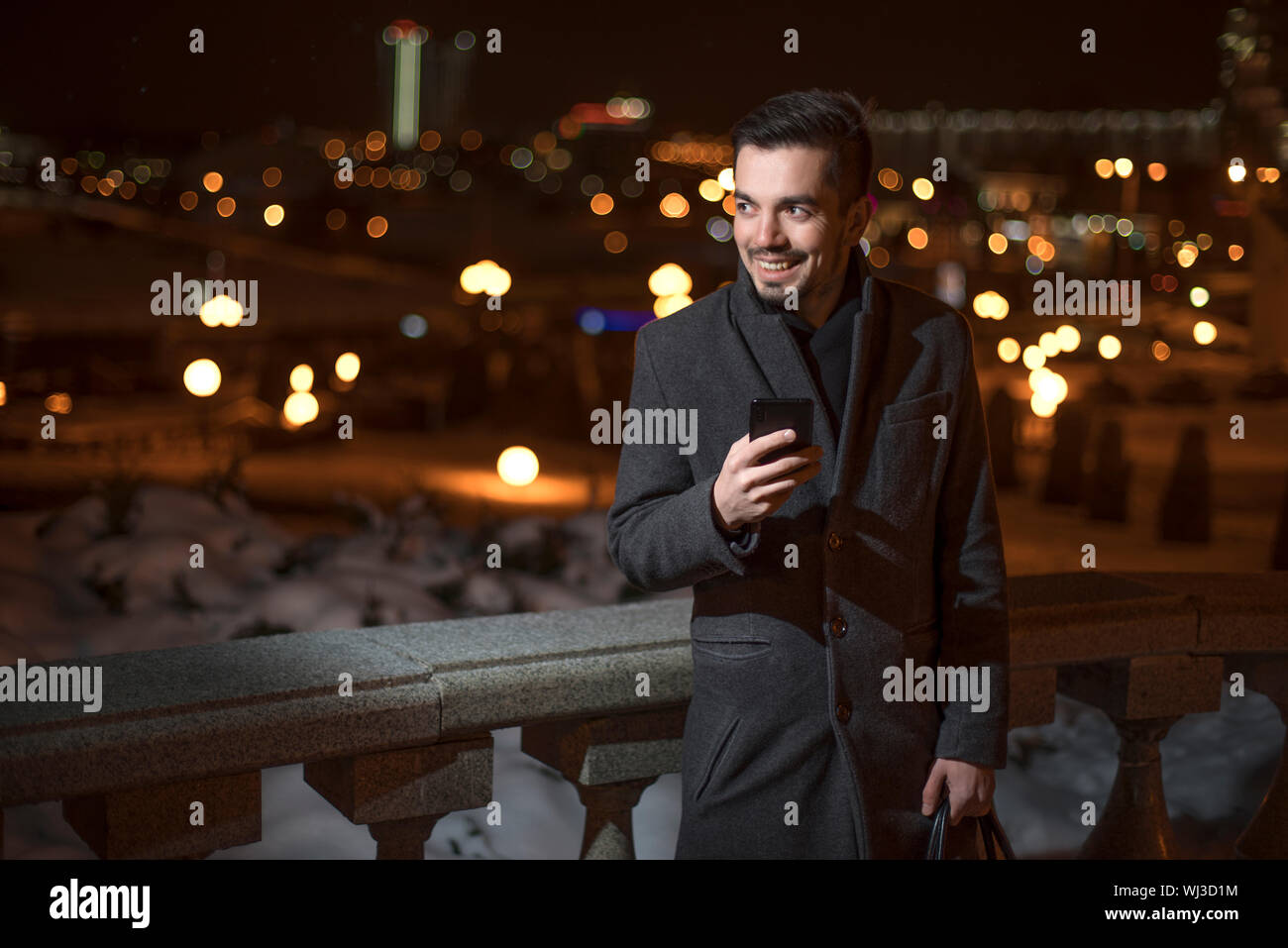 man in suit indoors looks at smartphone Stock Photo