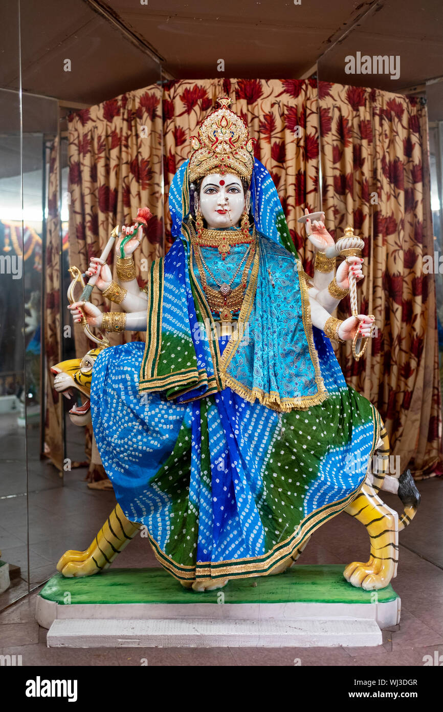 A statue of the Goddess Kushmanda, a manifestation of the deity Durga, dressed in blue & cyan at a Hindu temple in Woodside, Queens, New York City. Stock Photo