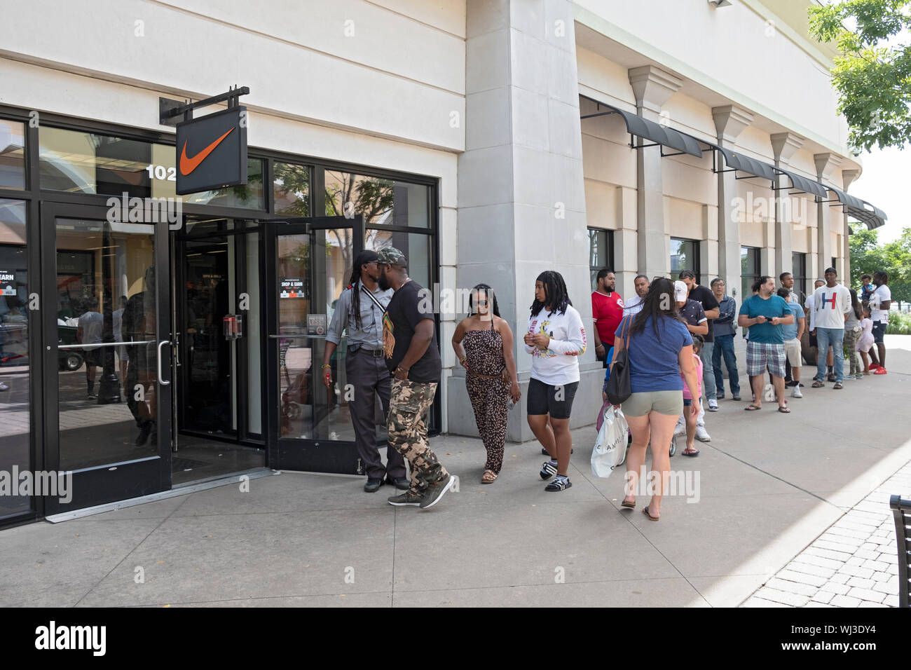 On Labor Day, a line of people wait to be allowed entrance into the Nike Outlet Store at the Tanger Mall in Deer Park, Long Island Stock Photo