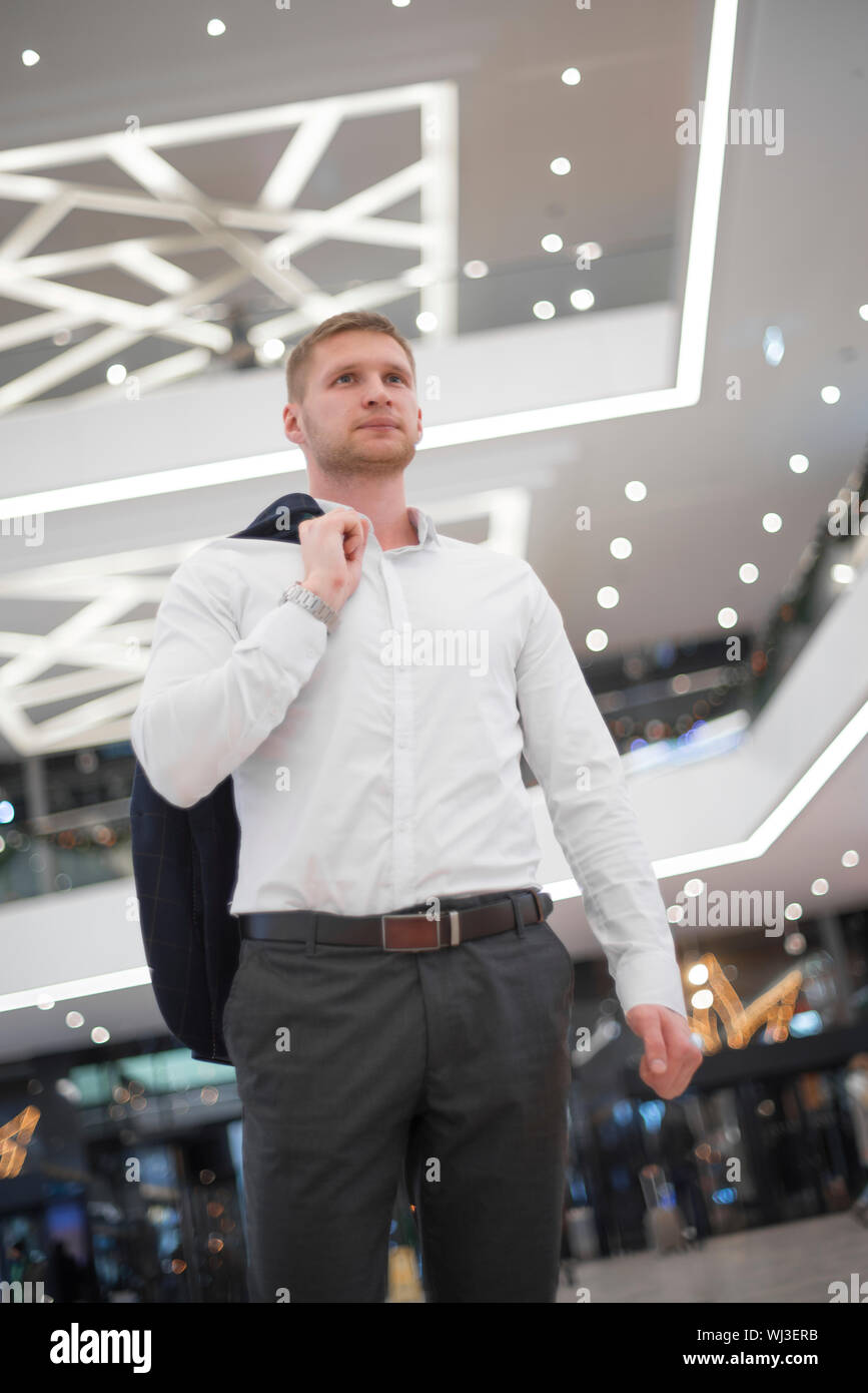 man with a jacket on his shoulder in the building Stock Photo