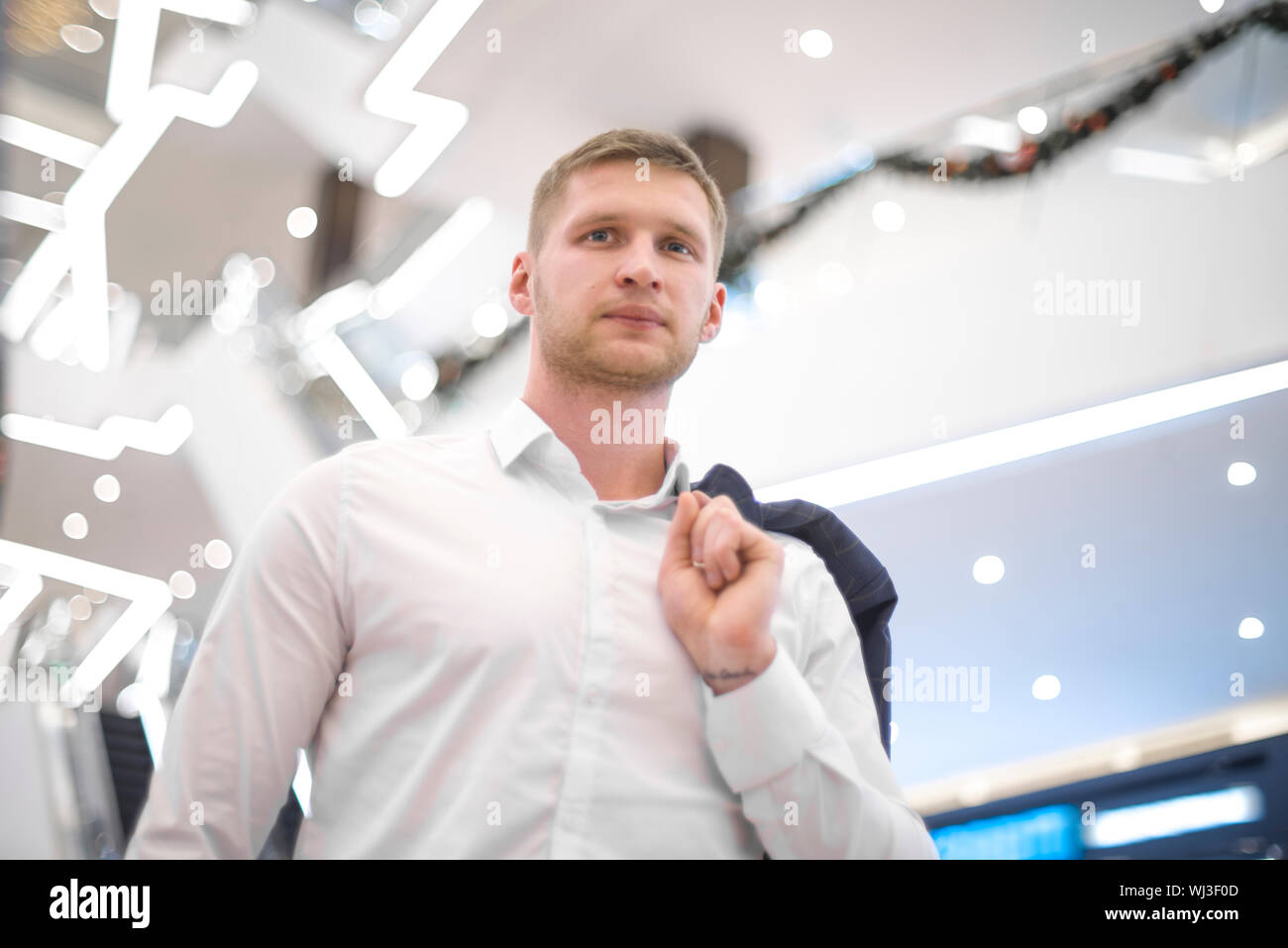 man with a jacket on his shoulder in the building Stock Photo