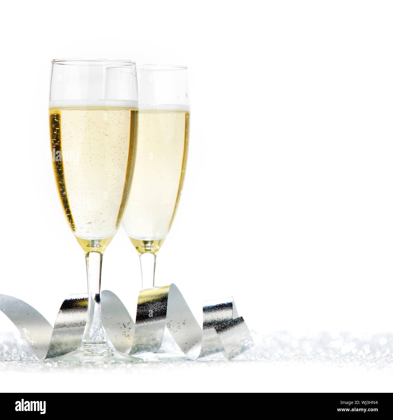 Two champagne flutes and decoration on gold shiny background Stock