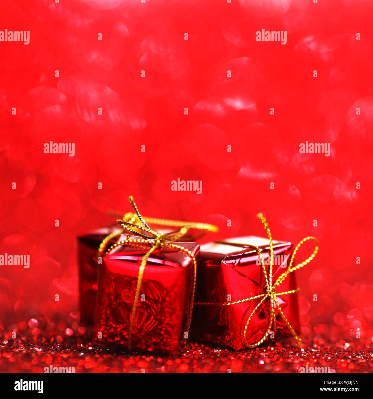 Red Christmas gift boxes on shiny glitter background Stock Photo Alamy